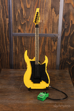 Ibanez RGBRYX-DY bouwgitaar rechtop op displaystandaard met groen TS808-model op houten oppervlak in Dijkmans-winkelstijl